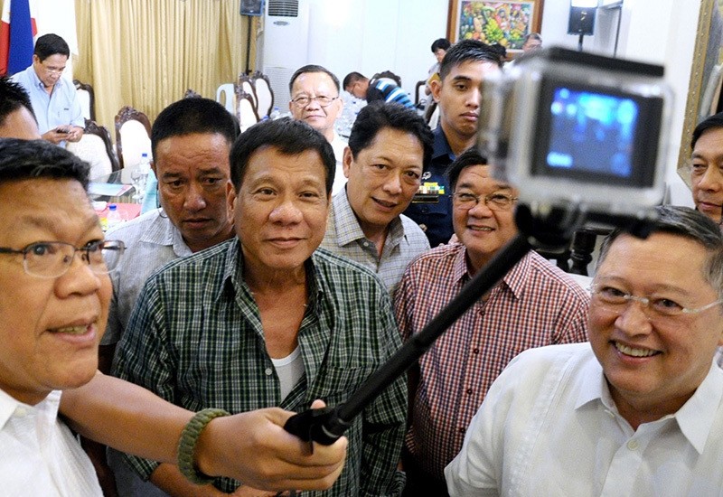 Philippines' President-elect Rodrigo Duterte (C) takes a selfie with Cabinet members during a press conference in the southern Philippine city of Davao on May 31, 2016 (AFP)