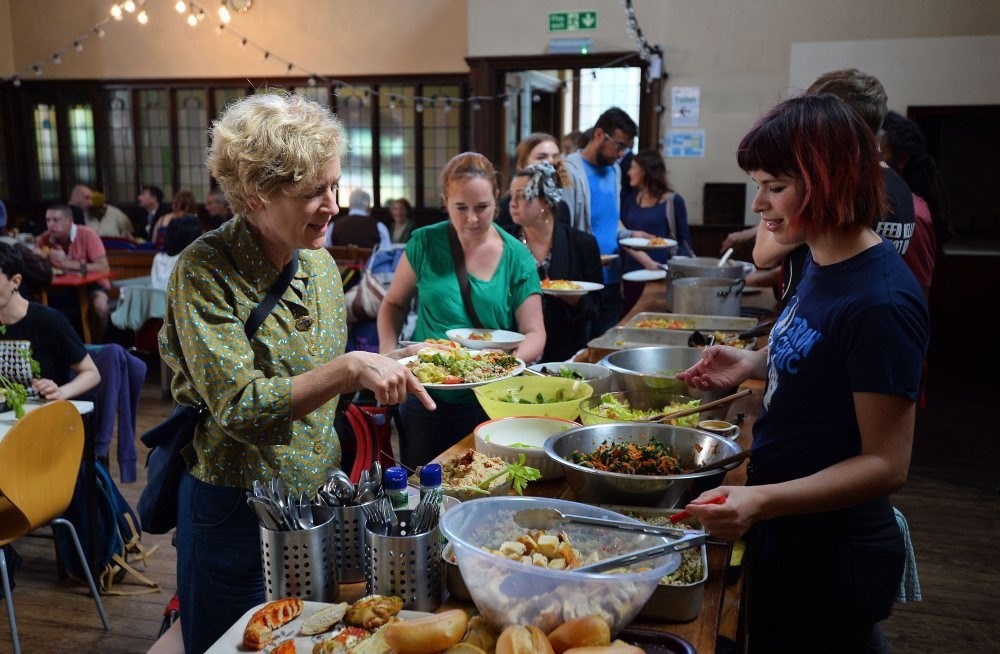 People eat at a Real Junk Food Project cafe in a Church in Brighton, southeast England. 
