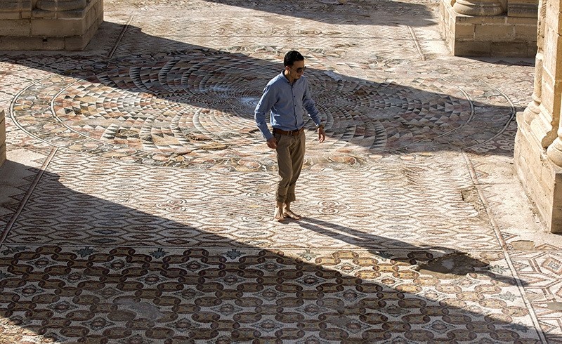 A Palestinian employee of the Palestinian Ministry of Tourism and Antiquities walks on a large Mosaic at Hisham's Palace in the West Bank city of Jericho, 20 October 2016 (EPA Photo)