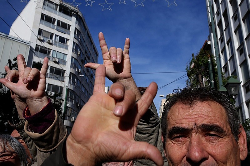 Deaf people make a gesture that in the sign language means 'Victory' as they protest against austerity measures in central Athens, Greece, 02 December 2016. (EPA Photo)