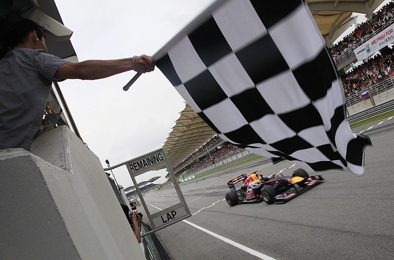 Red Bull Formula One driver Sebastian Vettel of Germany takes the checker flag during the Malaysian Formula One Grand Prix in Sepang, Malaysia. (AP Photo)