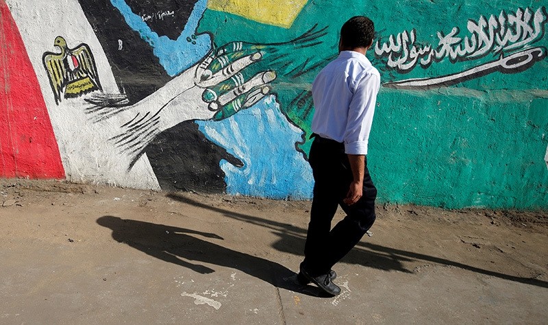 A man walks past graffiti depicting relations between Egypt and Saudi Arabia in Cairo, Egypt, October 12, 2016. Picture taken October 12, 2016. (Reuters Photo)