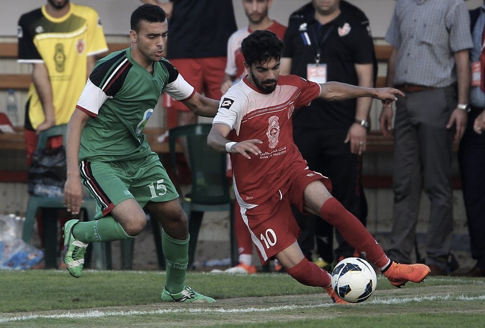 Palestinian Ahli al-Khalil player Fadi Zeidan (R) and Itihad Al-Shejaeiya player Mustafa Hasaballah (L) fight for the ball during a football match between the Ahli al-Khalil and Itihad Al-Shejaeiya in Al Yarmouk stadium in Gaza City.