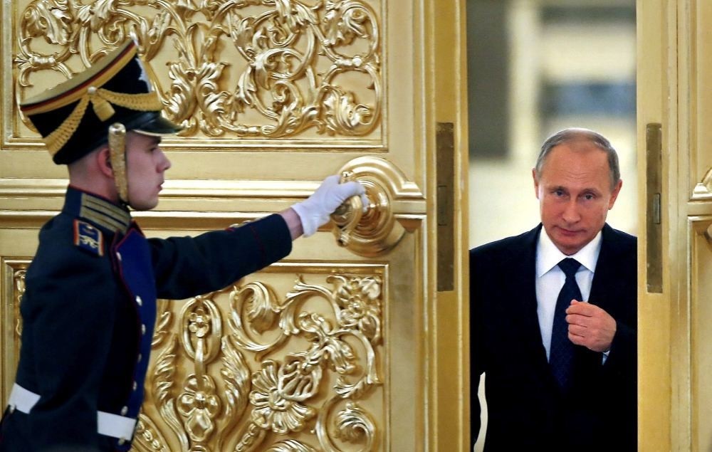 An honor guard opens the door as Russian President Vladimir Putin enters a hall at the Kremlin in Moscow.