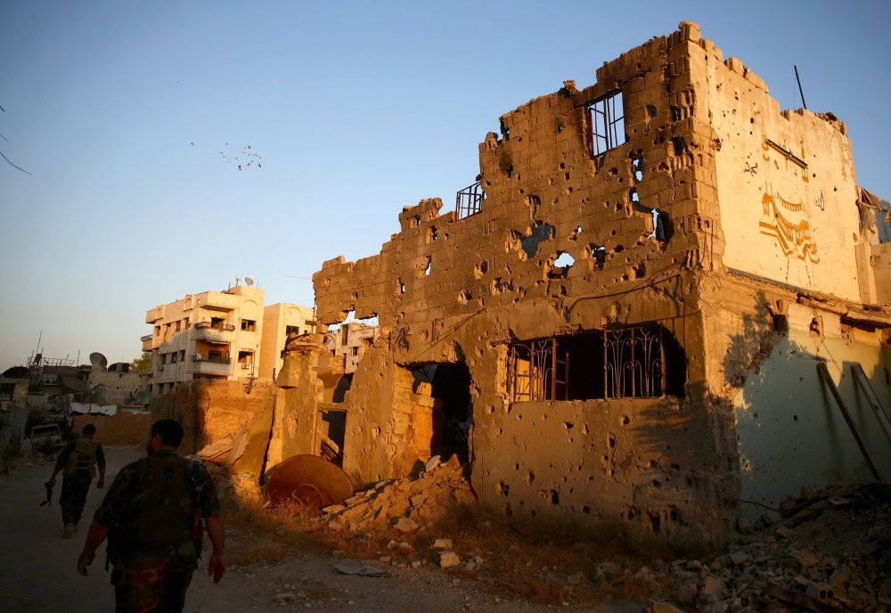 Free Syrian Army soldiers walking past damaged buildings in moderate-held Jobar, a suburb of Damascus, Syria, Sept. 6.