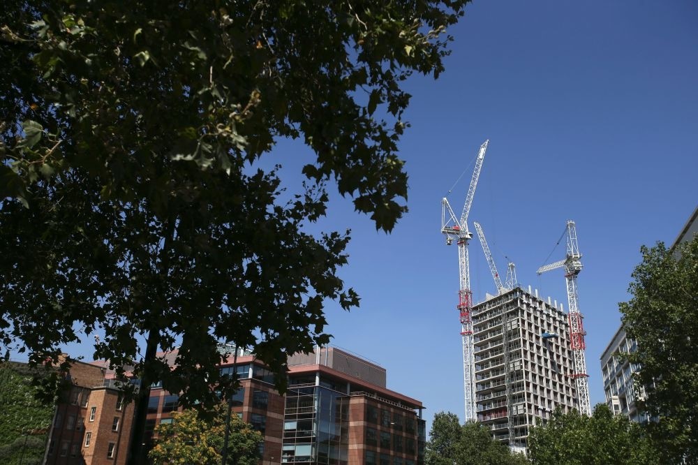 A picture shows cranes next to a block of flats under development in London on August 17.