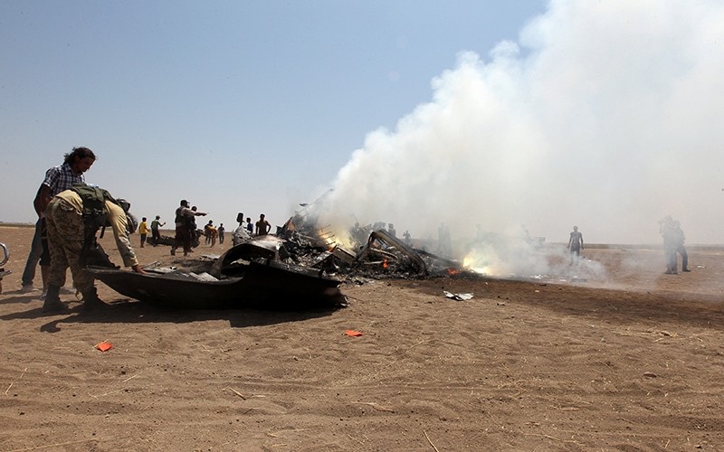Rebel fighters and civilians inspect the wreckage of a Russian helicopter that had been shot down in the north of Syria's rebel-held Idlib province (Reuters Photo)