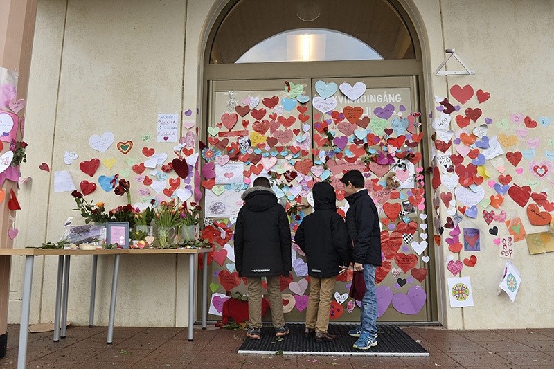 Boys read messages put up on the entrance to a mosque in Uppsala by neighbors pledging their support in Uppsala, Sweden, 02 January 2015. (EPA)