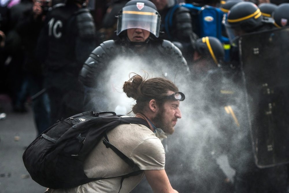 French police using tear gas against a demonstrator during a protest against the government's labor market reforms, at Place de la Nation, in Paris, May 26, 2016.