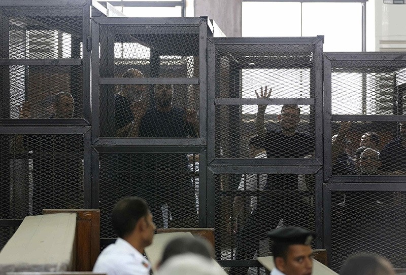 Muslim Brotherhood's General Guide Mohamed Badie (R) is pictured in a defendant's cage with other defendants in a courtroom in Cairo June 7, 2014. (Reuters Photo)