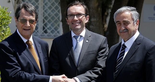 Greek Cypriot leader Nicos Anastasiades(L), Turkish Cypriot leader Mustafa Aku0131ncu0131(R), and UN envoy Espen Barth shake hands May 15, 2015. (AP Photo)