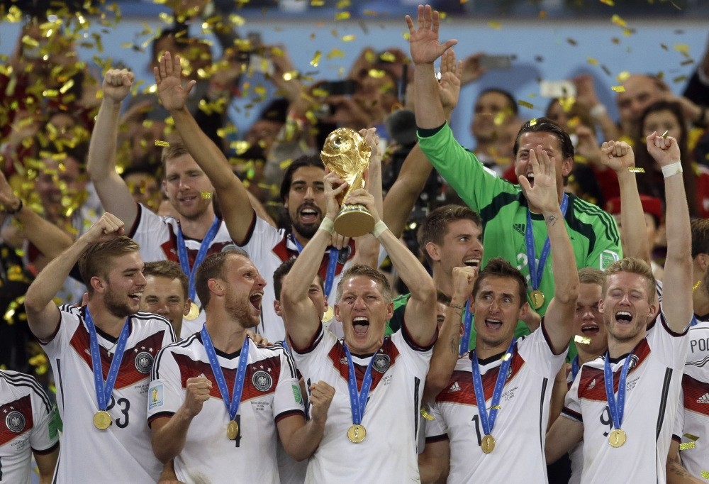 Germanyu2019s Bastian Schweinsteiger holds up the 2014 World Cup trophy as the team celebrates their 1-0 victor over Argentina after the World Cup final match between Germany and Argentina at the Maracana Stadium in Rio de Janeiro.