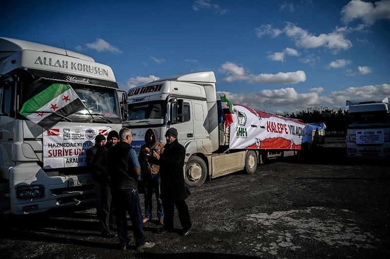 People stay next to an aidu00a0convoy to Aleppo organized by the IHH Humanitarian Relief Foundation about to leave, Dec. 14, 2016, Istanbul. (AFP Photo)u00a0