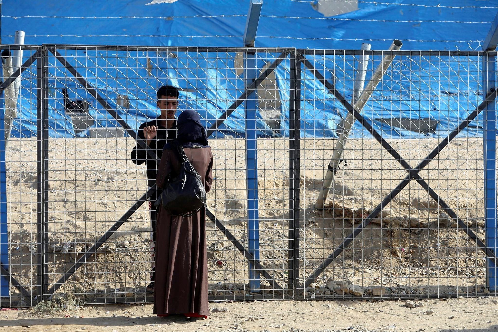A displaced woman who fled Daesh militants from Mosul speaks with her husband through a fence at Deepaka camp in the northwest of Erbil, Iraq, October 20, 2016. (Reuters Photo) 