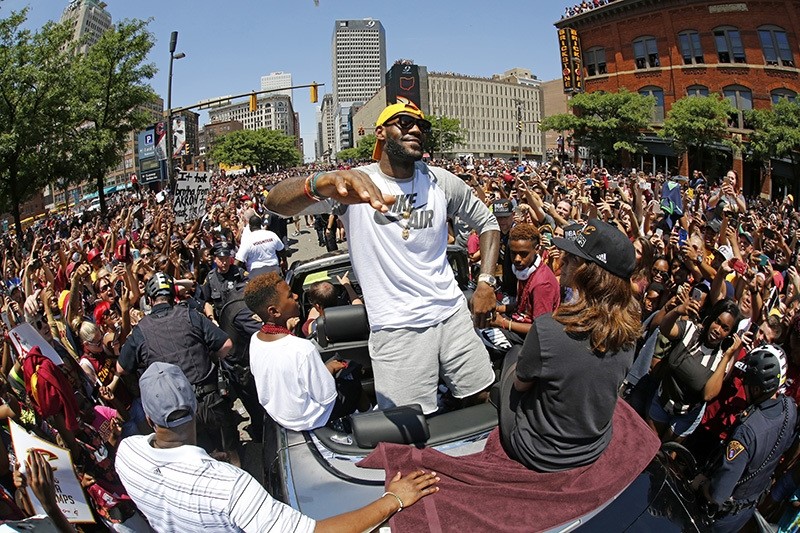 In this June 22, 2016, file photo, Cleveland Cavaliers' LeBron James, center, stands in the back of a Rolls-Royce as it makes it way through the crowd during a parade in downtown Cleveland celebrating the team's NBA championship. (AP Photo)