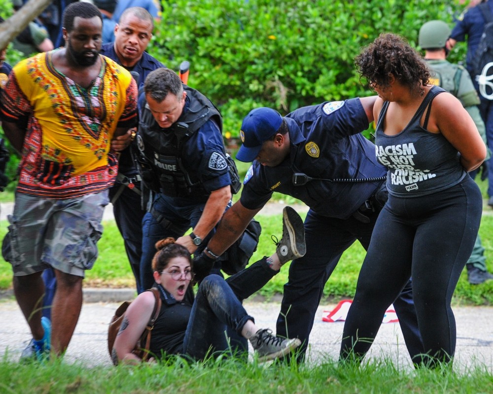 Police detain protesters as they try to clear streets while protesters were gathering against another group of protesters in Baton Rouge, La., July 10.