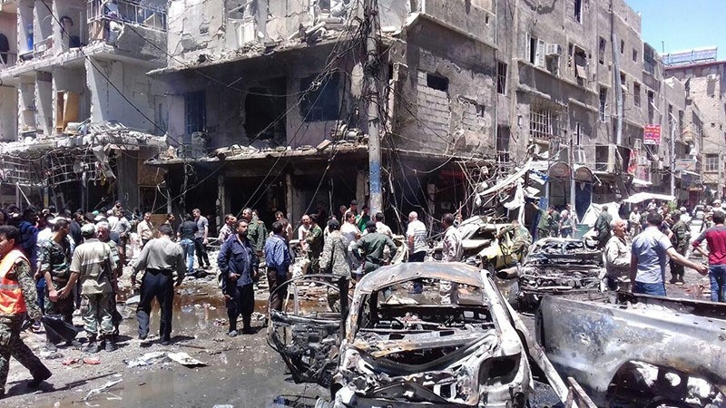A handout picture released by the official Syrian Arab News Agency (SANA) on June 11, 2016 shows Syrians gathering at the scene of a double bomb attack outside the Sayyida Zeinab shrine (AFP)