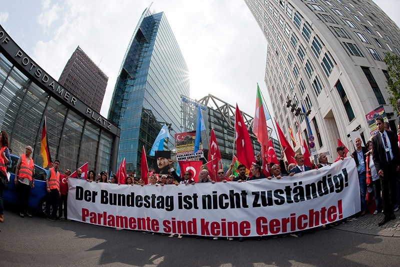 Demonstrators hold up a banner reading 'The Bundestag is not responsible! Parliaments are not courts!' on Potsdamer Platz in Berlin, Germany, 28 May 2016. (EPA Photo)