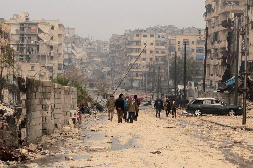 People walk at a damaged area one day after a ceasefire was announced, at al-Mashhad neighborhood in the rebel-held part of Aleppo, Syria, 14 December 2016. (EPA Photo)