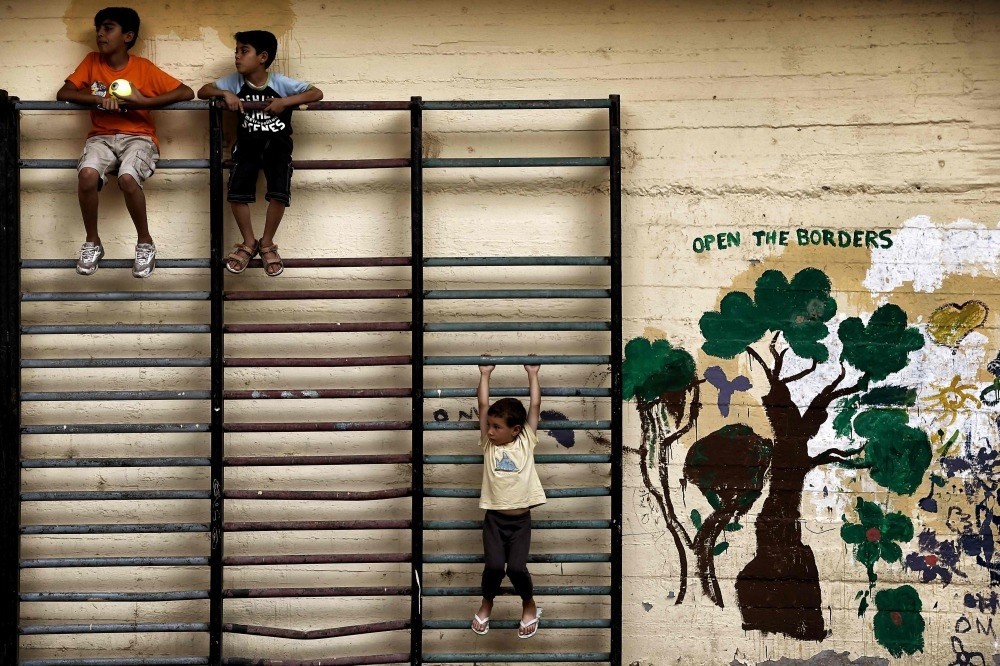 Children playing in the courtyard of an abandoned school used by volunteers for hosting Syrian and Afghan refugees in Athens, July 1, 2016.
