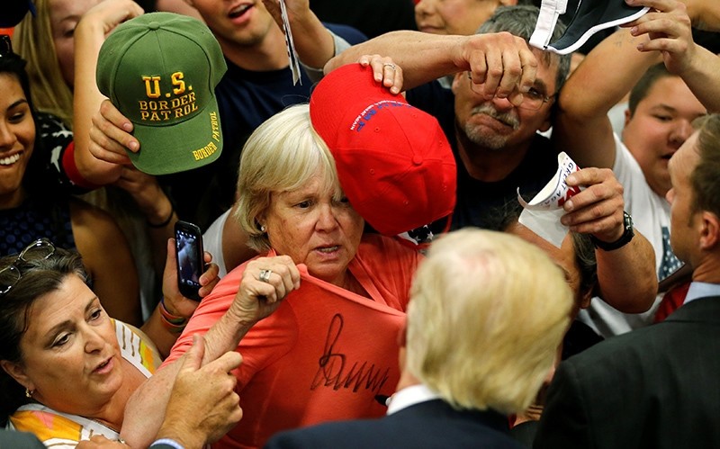 Republican U.S. presidential candidate Donald Trump signs a woman's shirt after a rally with supporters in Albuquerque, New Mexico, U.S. May 24, 2016 (Reuters Photo)