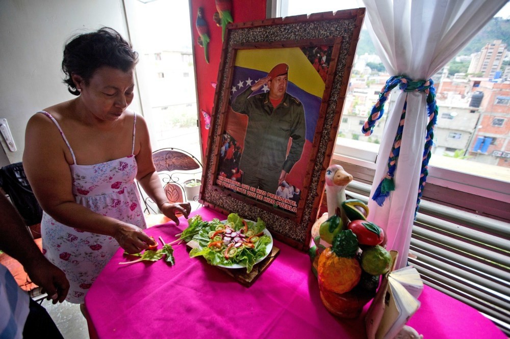 Petra Lezama prepares a salad with vegetables from her roof garden in Caracas, where she keeps a photo of Venezuelau2019s late President Hugo Chavez.