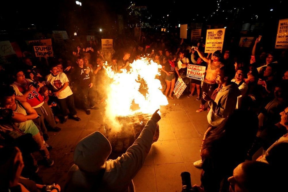 A Donald Trump pinata is burned by people protesting U.S. president-elect Donald Trump in downtown Los Angeles, California, Nov. 9.