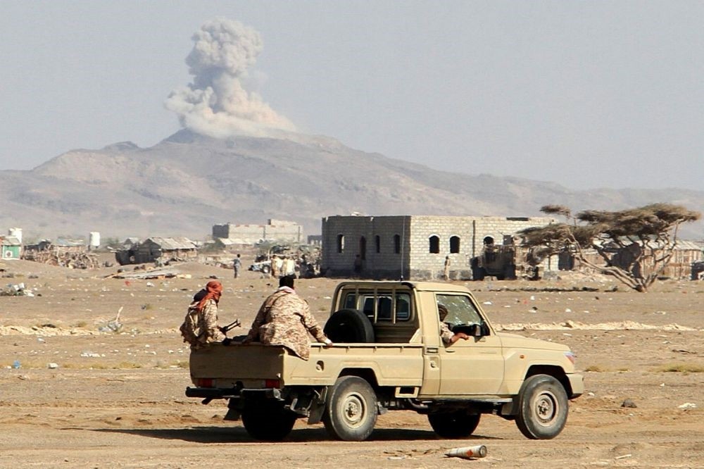 Smoke billows in the distance as Yemeni pro-government forces patrol during clashes against Shiite rebels in Yemen's western Dhubab district on Jan. 9.