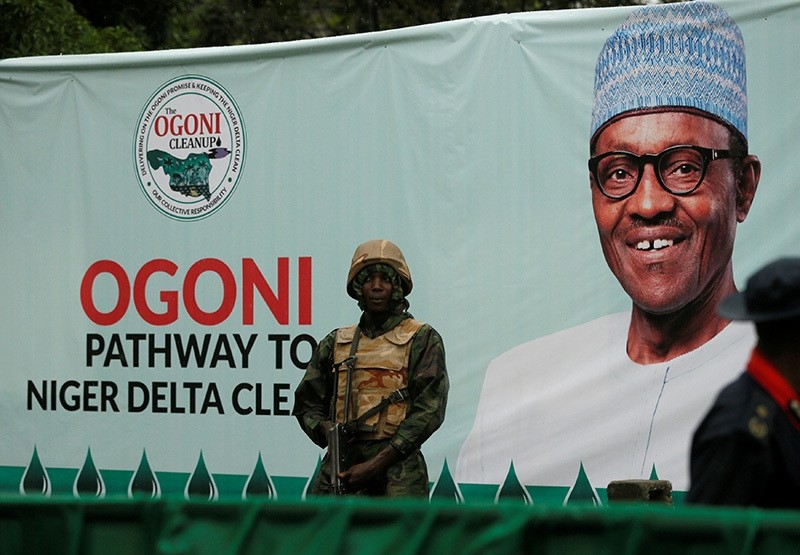 A soldier stands guard in front of a banner with a picture of Nigeria's President Muhammadu Buhari in Gokana, Nigeria on June 2, 2016 (Reuters Photo)