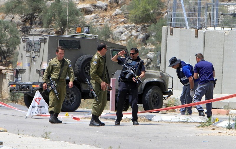 Israeli soldiers and policemen inspect the scene where a Palestinian woman was shot dead by Israeli forces at Ennab Israeli checkpoint near the West Bank city of Tulkarm June 2, 2016.  REUTERS