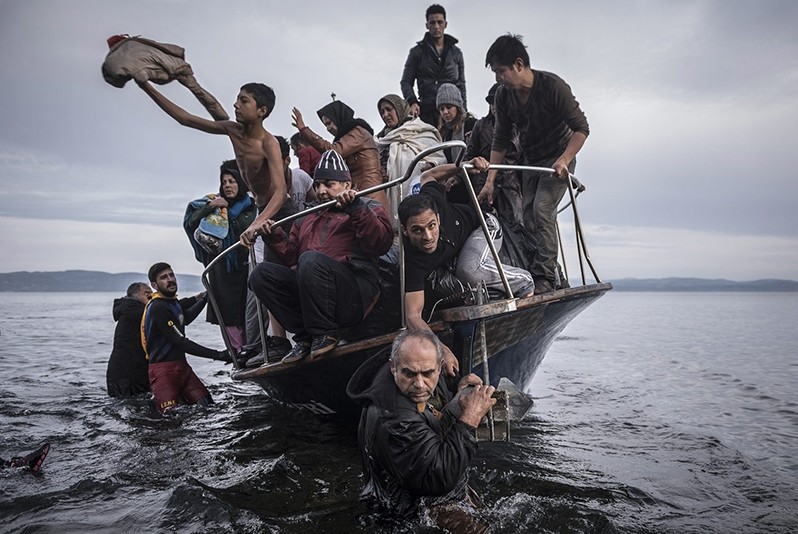 In this Nov. 1, 2015 photo by Sergey Ponomarev, migrants arrive by a Turkish boat near the village of Skala, on the Greek island of Lesbos. (AP Photo)