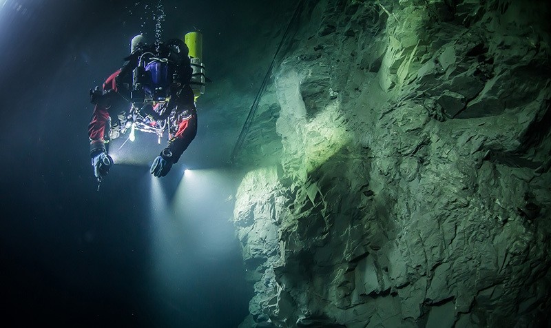 In this underwater photo taken Aug. 21, 2015, in the flooded Hranicka Abyss, Czech Republic, Polish explorer Krzysztof Starnawski is seen examining the limestone crevasse (AP Photo)