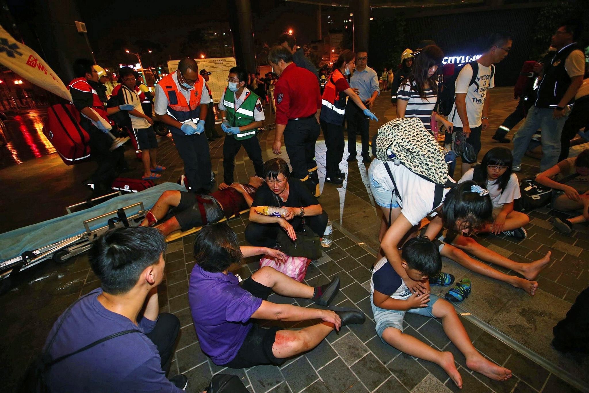 Injured people are helped by emergency rescue workers outside a station after an explosion on a passenger train in Taipei, Taiwan, Thursday, July 7, 2016. (AP Photo)