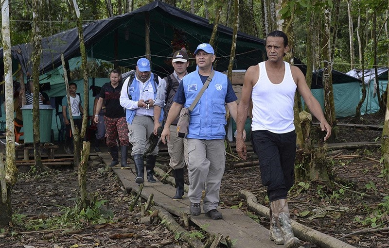 FARC guerrilla commander Pedro (R) walks with members of the United Nations Observation Mission during thier visit at the Front 34 Alberto Martinez encampment (AFP Photo)