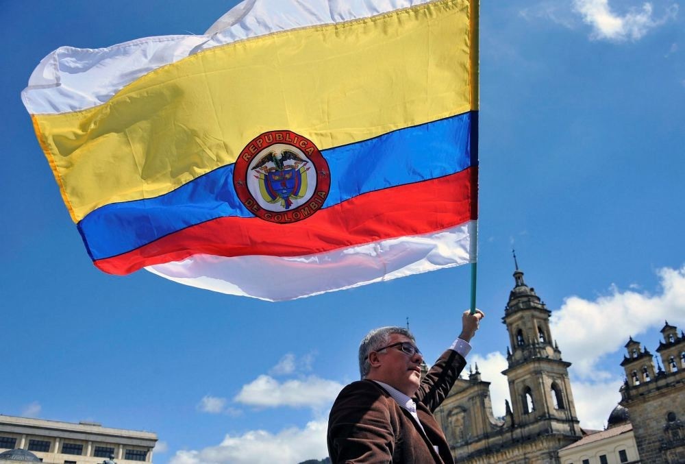 A man holds a Colombian national flag with white stripes during a demo to demand the immediate endorsement of the new peace agreement between the Colombian government and the FARC guerrilla outside the Colombian Congress in Bogota, Nov. 30.