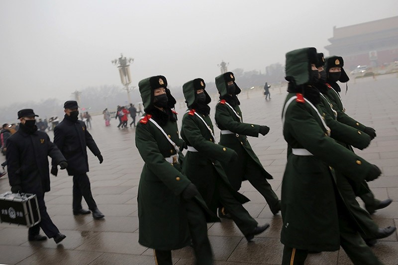 Paramilitary policemen wearing masks march on a cold morning following a flag-raising ceremony amid heavy smog at Tiananmen Square, after the city issued its first ever ,red alert, for air pollution, in Beijing on Dec. 9, 2015. (Reuters Photo)