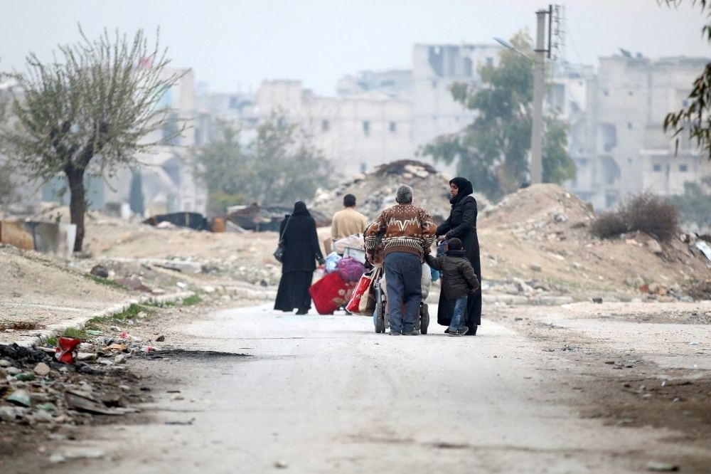 People carry their belongings as they flee the Kadi Askar area towards Bustan al-Qasr neighbourhood, in the opposition-held area of Aleppo, Syria, Dec. 5.