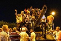 People stand on an abandoned tank and cheer after the failed coup attempt, in Istanbul.