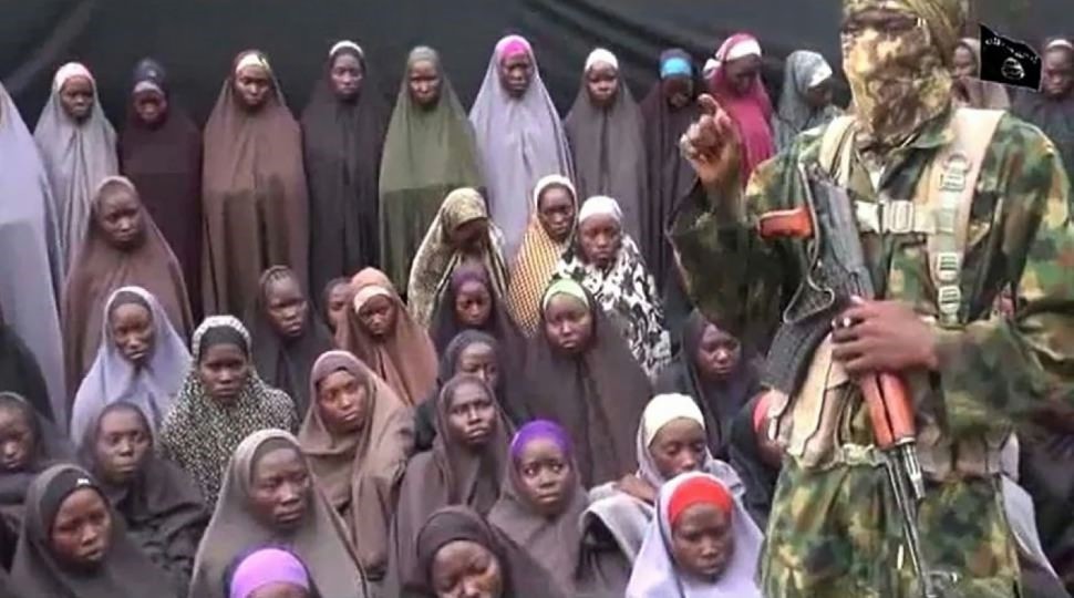 Image taken from a video released on YouTube purports to show a Boko Haram fighter at an undisclosed location in front of girls allegedly kidnapped in April 2014.