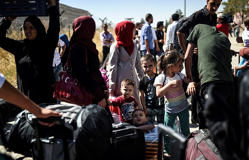  Syrian refugees on their way back to the Syrian city of Jarablus on Sept. 7 at the Karkamu0131u015f crossing gate, in the southern region of Turkeyu2019s Kilis province. (AFP Photo)