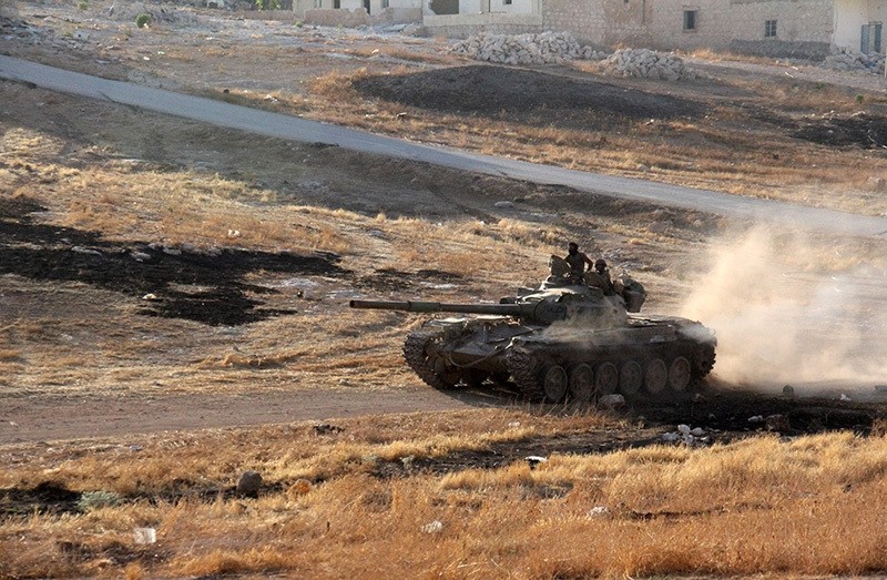 Opposition fighters drive a tank in the Al-Huweiz area on southern outskirts of Aleppo as they battle to break the government siege on the northern Syrian city on August 2, 2016. (AFP Photo)