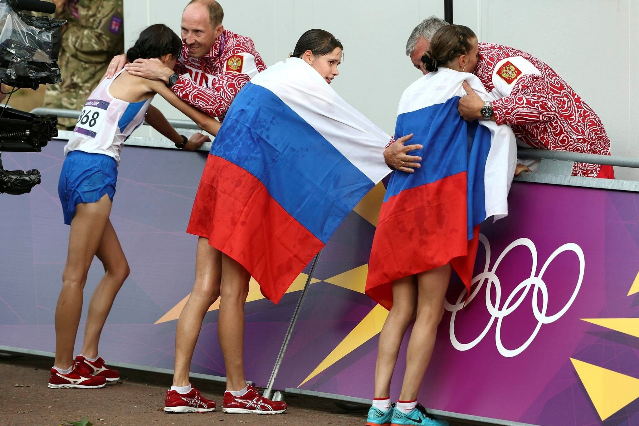Russia coach Alexey Melnikov congratulates Olga Kaniskina, right, and Russia men's gold medalist Sergey Kirdyapkin congratulates Anisya Kirdyapkina, left, at the 2012 Summer Olympics in London. (AP Photo)