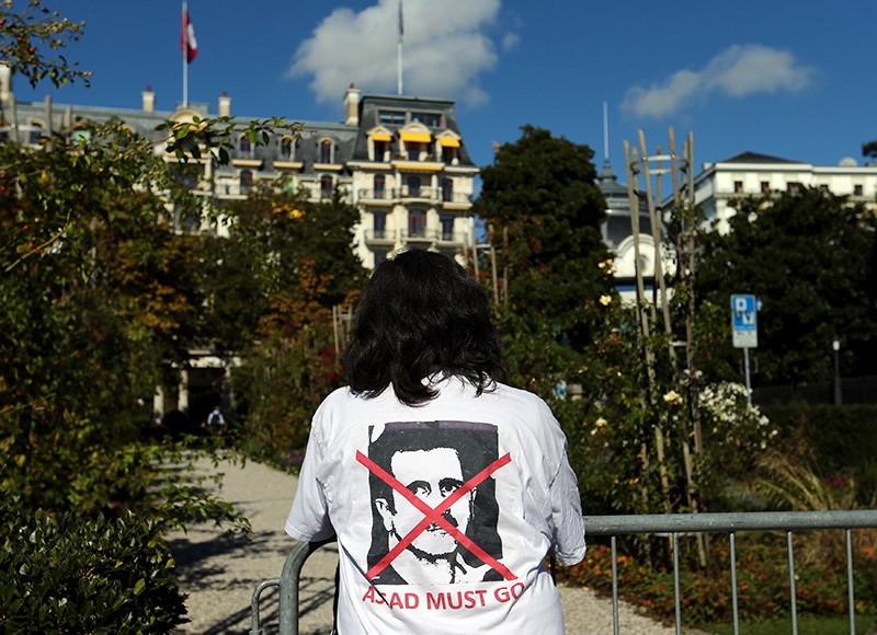 A woman stands outside the Beau-Rivage Palace ahead of Syria talks in Lausanne, Switzerland, October 15, 2016. The T-shirt reads: ,Assad must go,. (Reuters Photo)