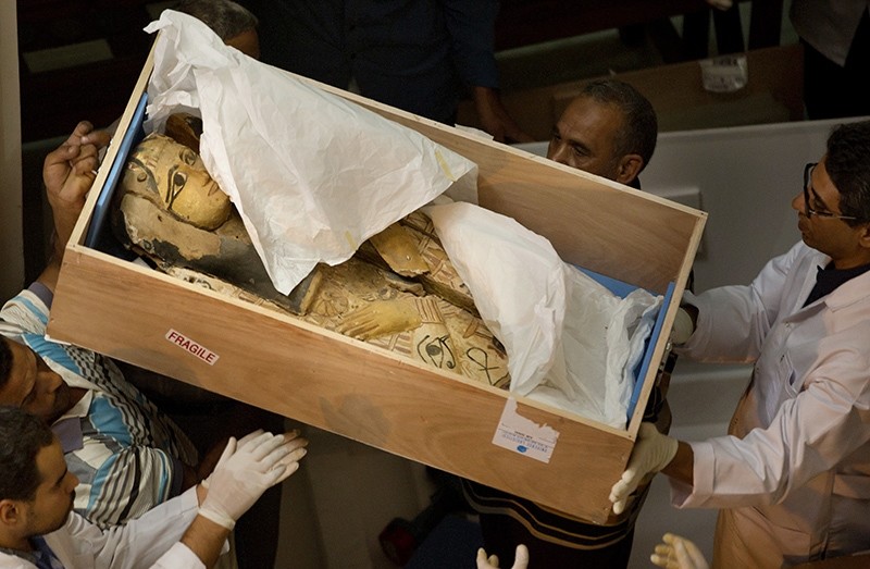 Egyptian antiquities officials carry a lid of a sarcophagus on its arrival to the Egyptian Museum in Cairo, Egypt, Tuesday, June 21, 2016 (AP Photo)