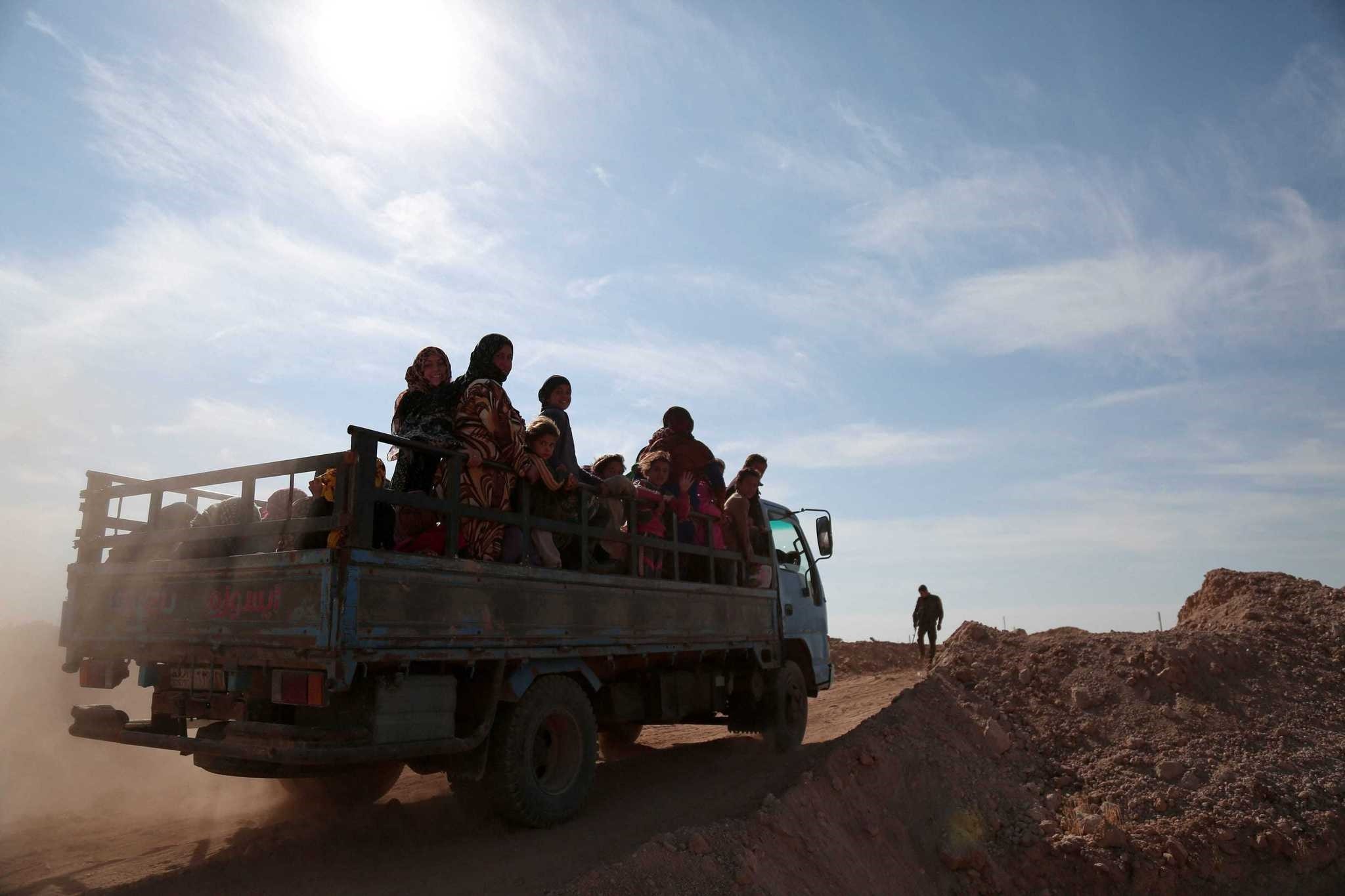 People fleeing areas of conflict ride a vehicle, north of Raqqa city, Syria, Nov. 8, 2016.