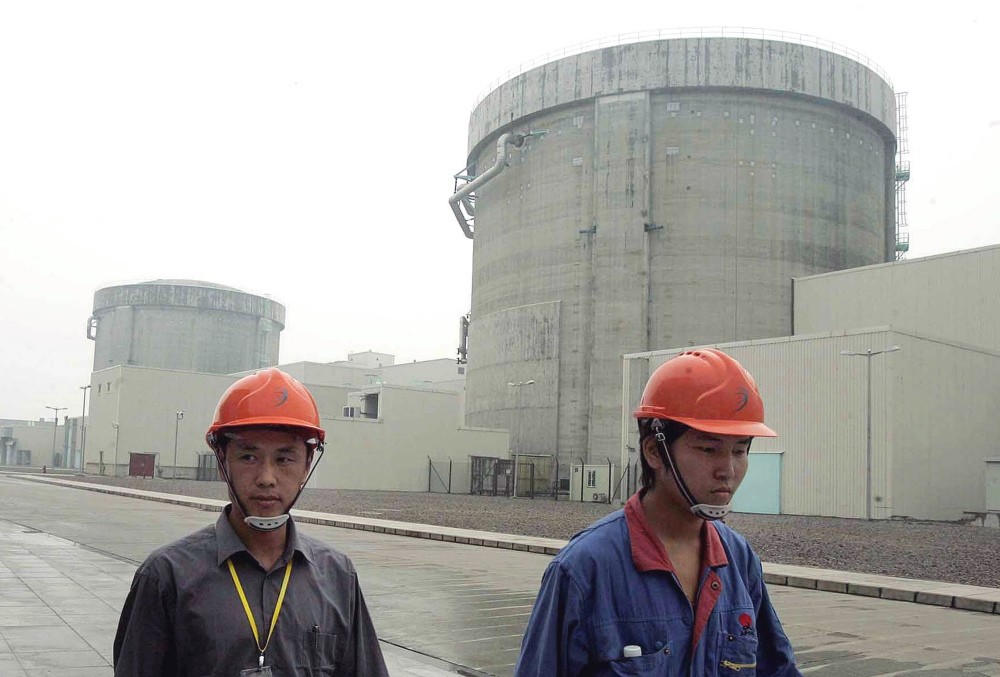 Workers walk past a part of the Qinshan No. 2 Nuclear Power Plant, China's first self-designed and self-built national commercial nuclear power plant in Qinshan, about 125 kilometers southwest of Shanghai, China.