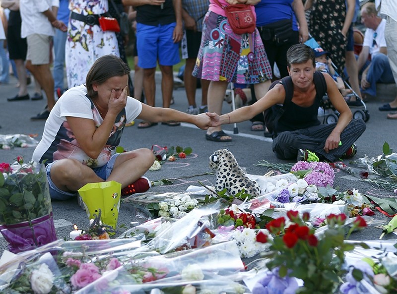 People pay tribute to the victims at the site of a deadly truck attack on the famed Promenade des Anglais in Nice, southern France, Saturday, July 16, 2016. (AP Photo)
