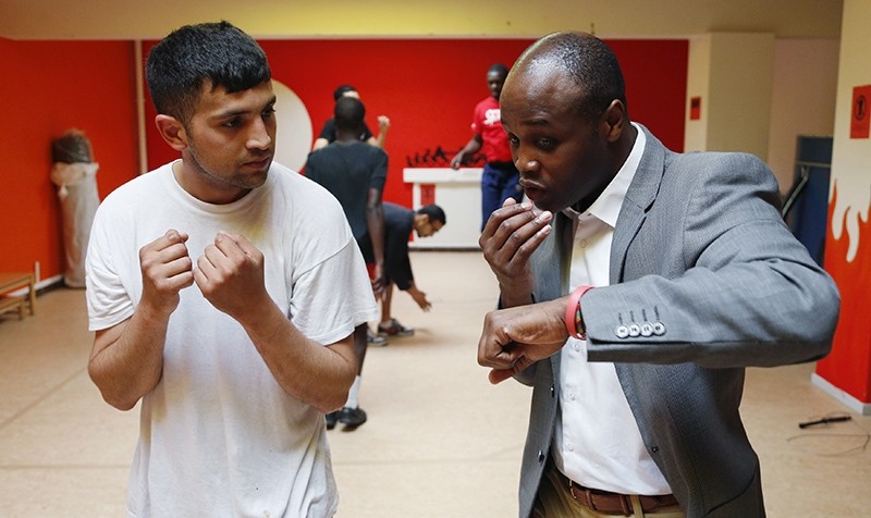 Former Belgian boxing champion Bea Diallo gives instructions to unemployed Mohamed Sammar (L) during a ,Fit for a job, boxing class in Brussels July 5, 2013 (Reuters Photo)