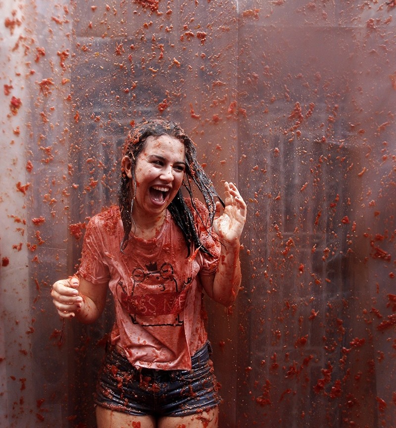 A woman is covered in tomato as she takes part during the traditional annual tomato fight, known as 'Tomatina' in Bunol, eastern Spain, 31 August 2016. (AP Photo)
