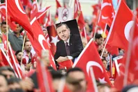 A picture of President Erdou011fan is framed by national flags during a demonstration in Cologne, Germany (AP Photo)